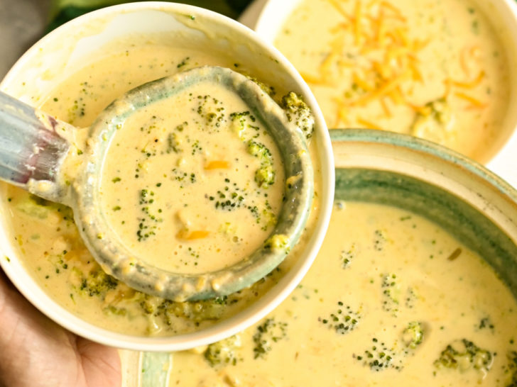 low carb broccoli cheese soup being served into white bowls