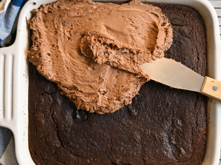 keto Hershey's chocolate cake being frosted with sugar-free chocolate buttercream frosting