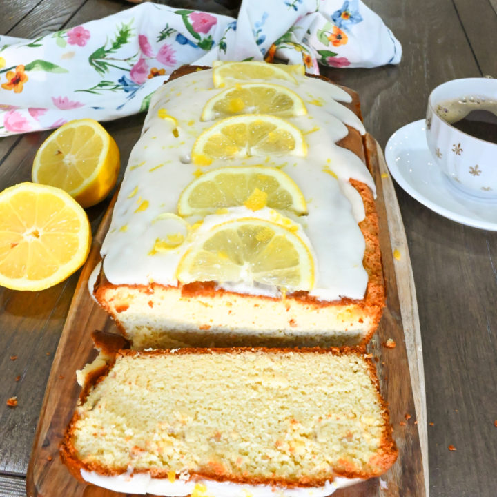 keto lemon pound cake loaf sliced on a wood board and ready to serve