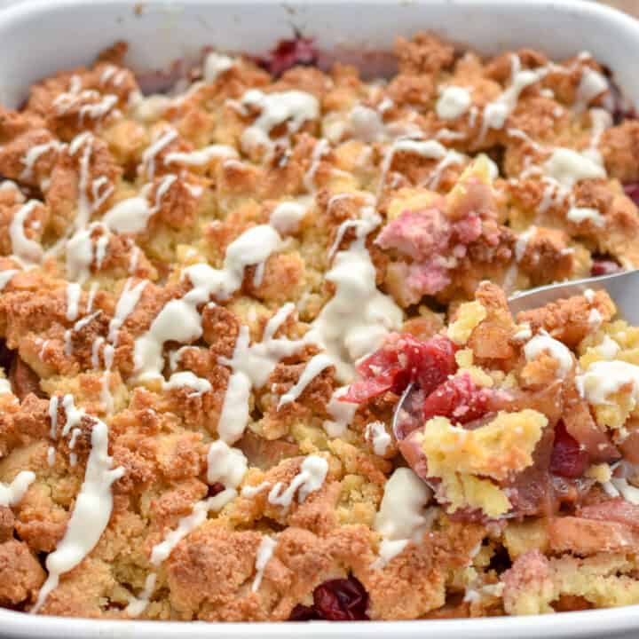 keto apple cranberry cobbler in a white baking dish being served