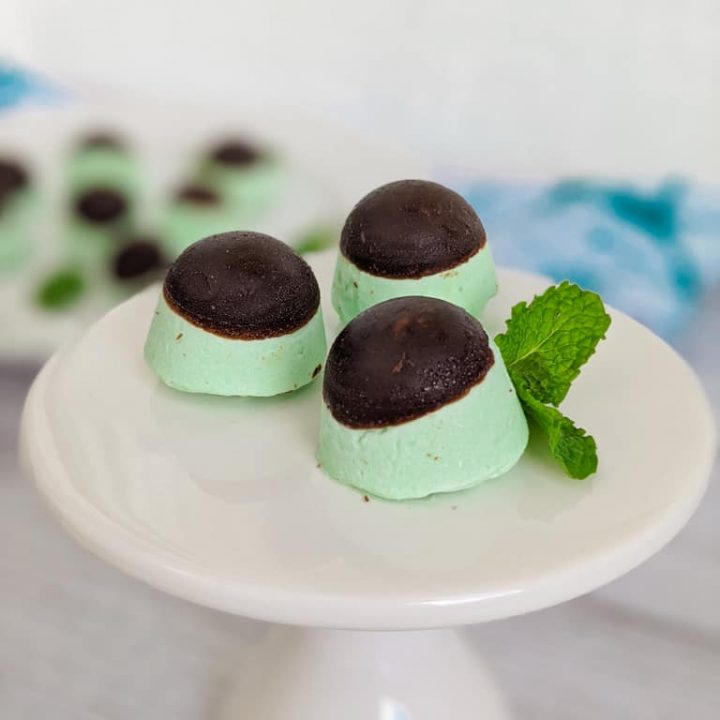 keto peppermint cream cheese fat bombs with mint leaves on small white pedestal