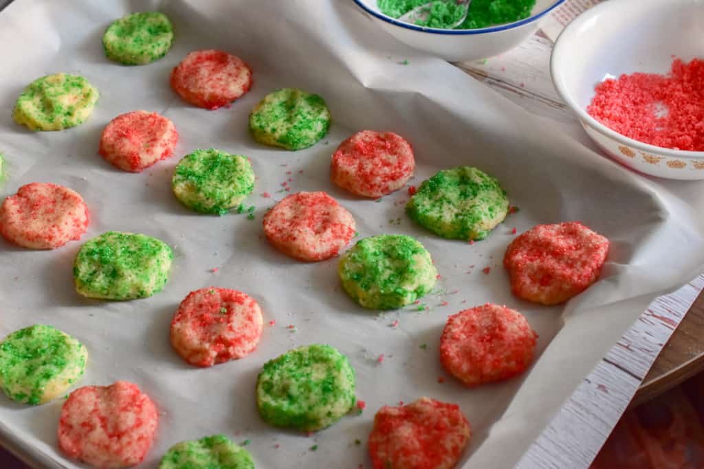 keto soft sugar cookies on baking sheet with colored sugar bowls in background