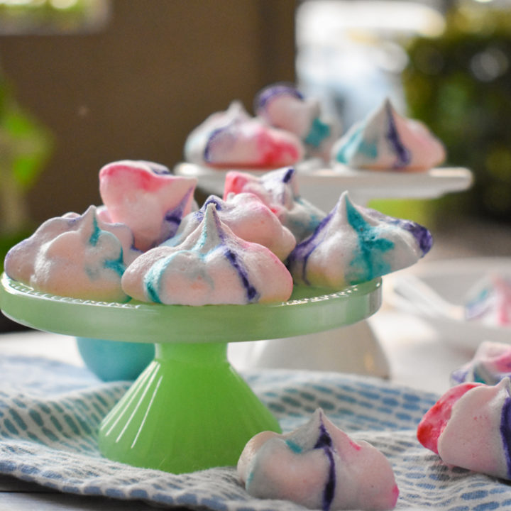 keto french meringues on a green pedestal with blue dyed eggs in the background