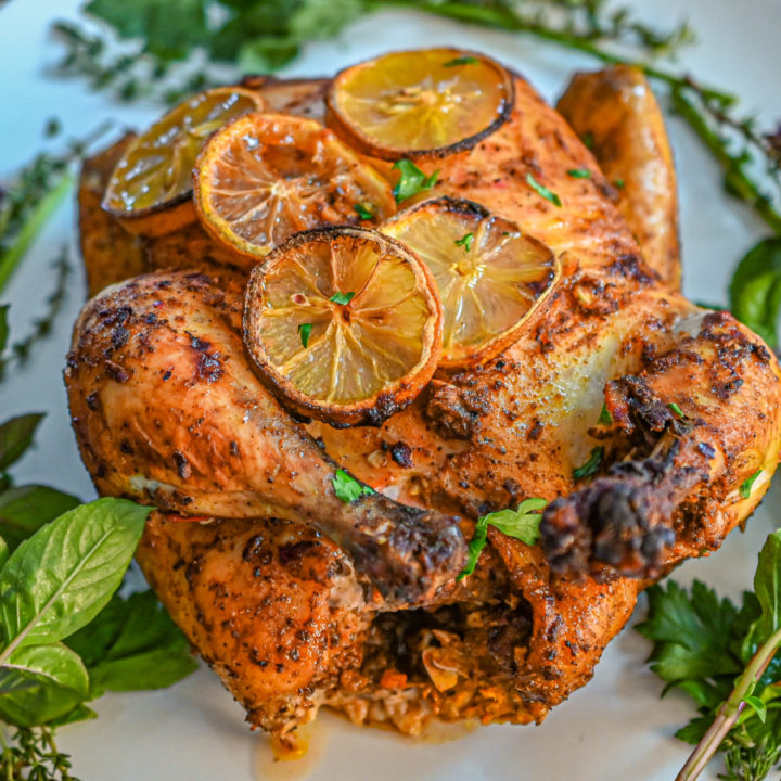 keto sumac harissa chicken on a white plater with herbs