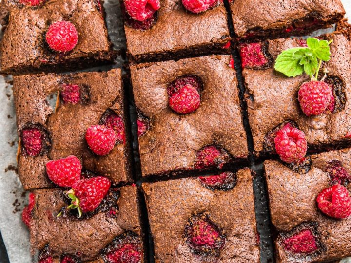 keto raspberry brownies sliced on parchment paper close up