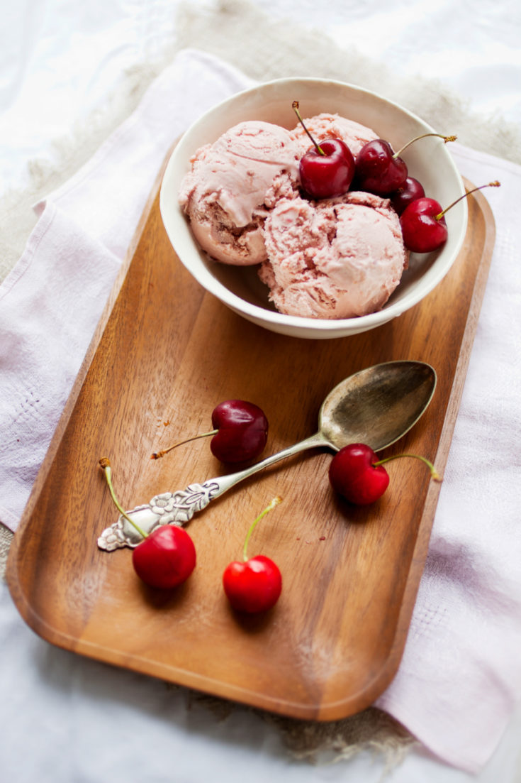 keto dark cherry ice cream served in a white bowl on a wooden board