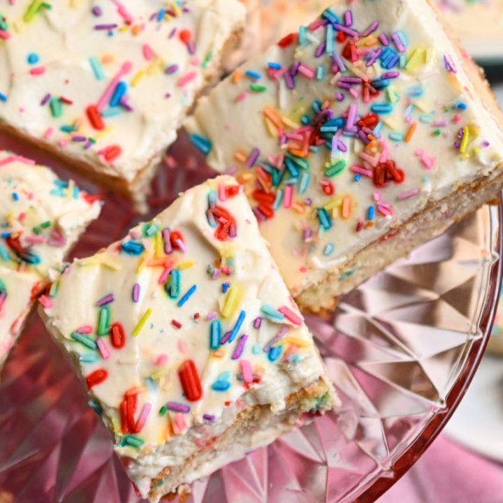 Keto Birthday Cake funfetti slices on a clear pink pedestal stand