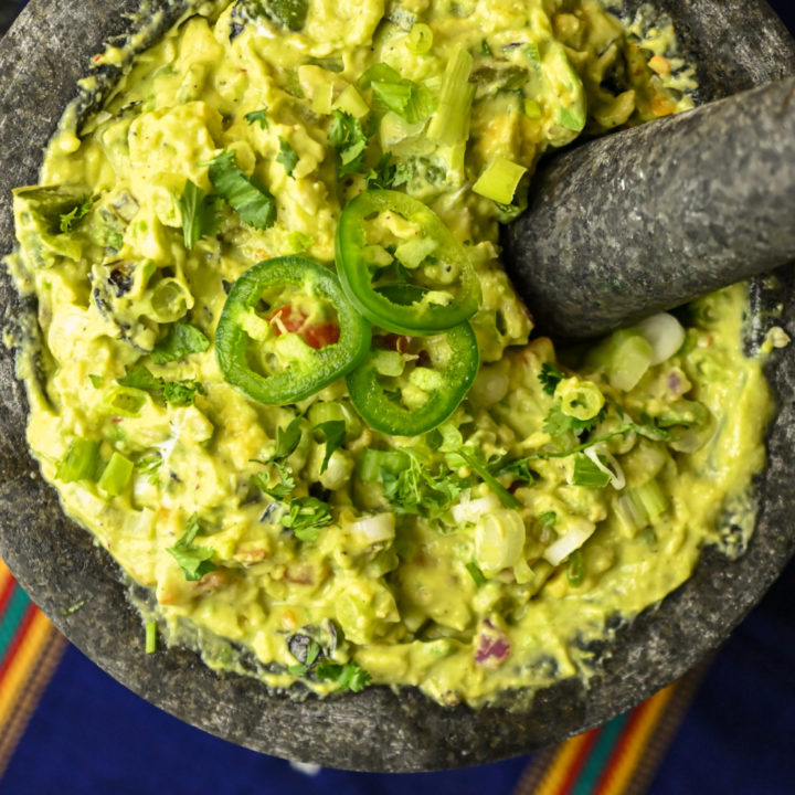 homemade spicy guacamole recipe served in a extra large grey mortar bowl