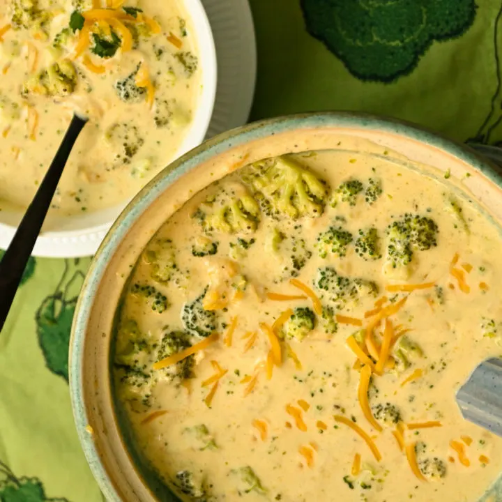 Keto broccoli cheese soup made in a crockpot and served in a green soup tureen and a white bowl