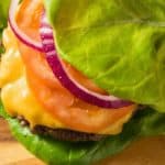 Lettuce wrapped burger served on a wood plank