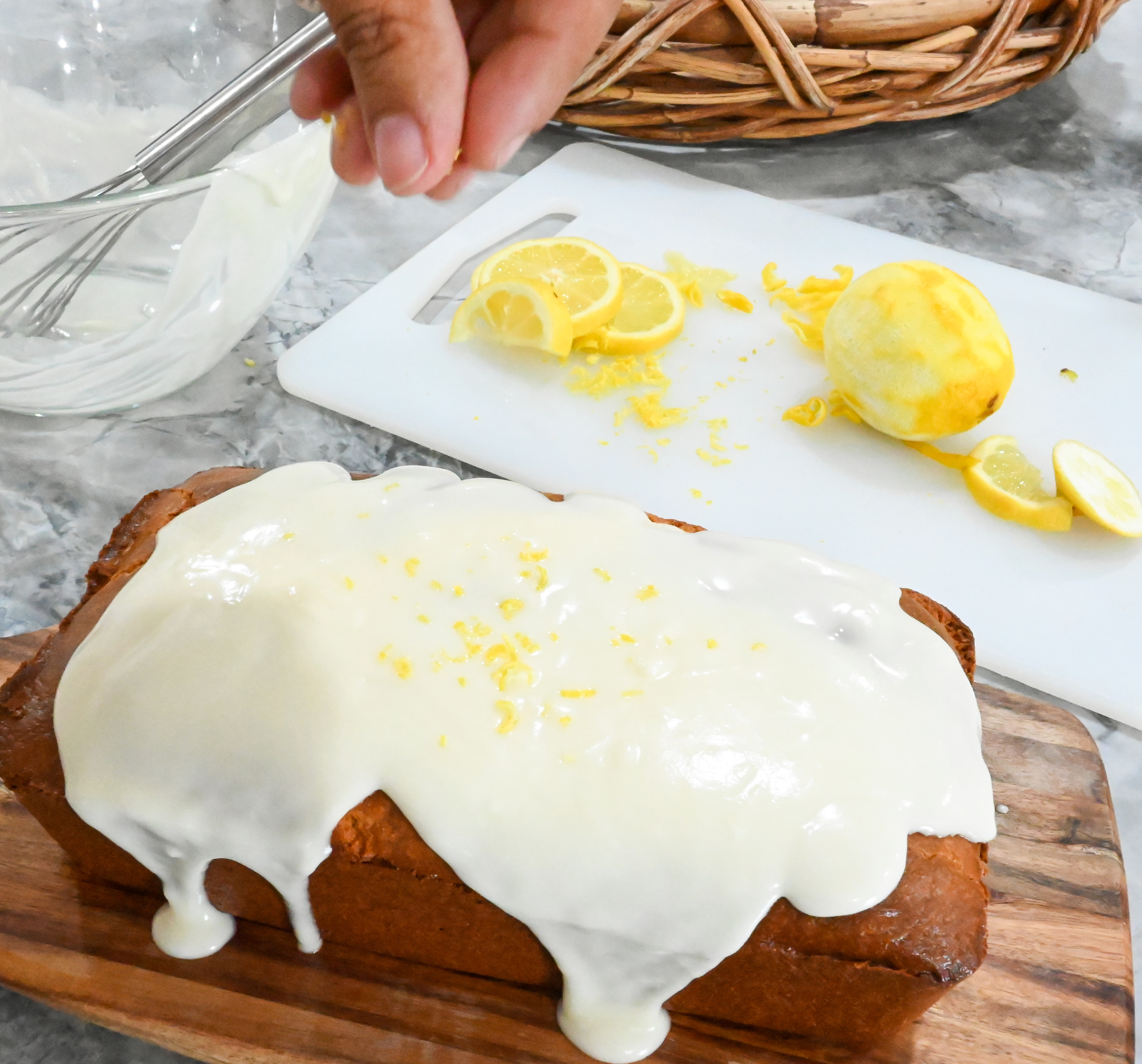 keto lemon pound cake being topped with lemon zest