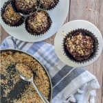 keto chocolate toasted coconut cupcakes on white plates on a wood background