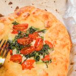 Keto Freeform Pizza Up Close With Fork On Parchment Paper