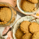 Almond flour peanut butter cookies displayed in different size plates and inside a clear cookie jar