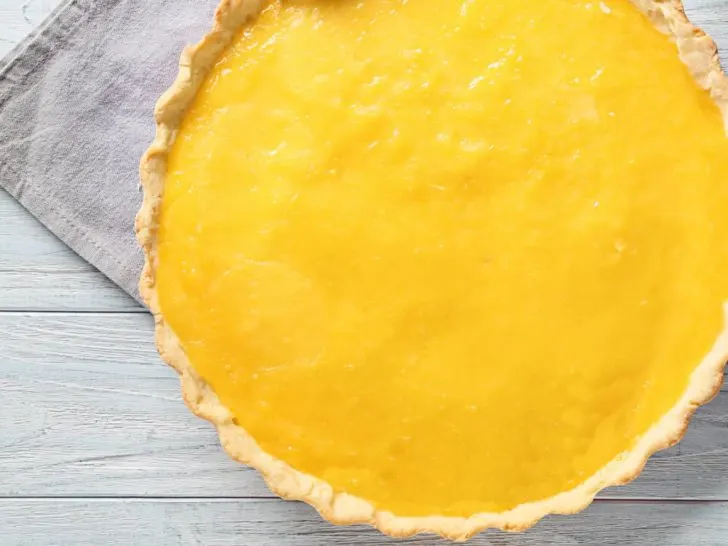 sugar-free lemon curd low carb pie whole on white wood counter