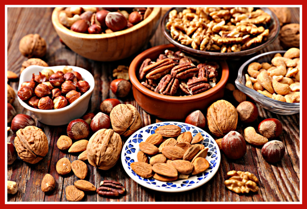 mixed nuts in several bowls on a wooden table