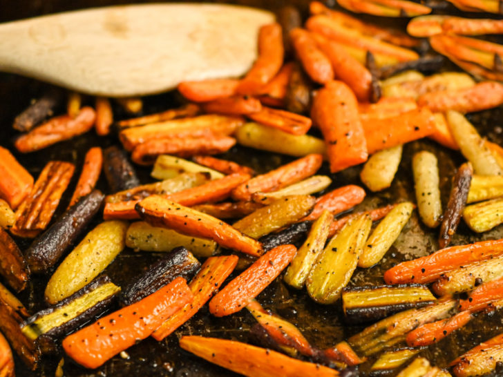 roasted carrots on a dark sheet pan