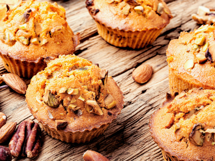 keto high fiber muffins on a wooden table with scattered nuts