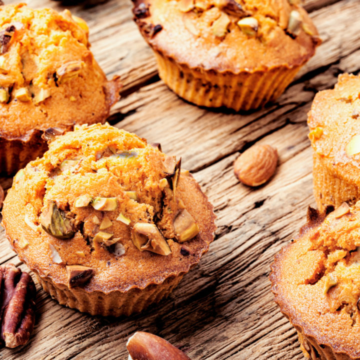 keto high fiber muffins on a wooden table with scattered nuts