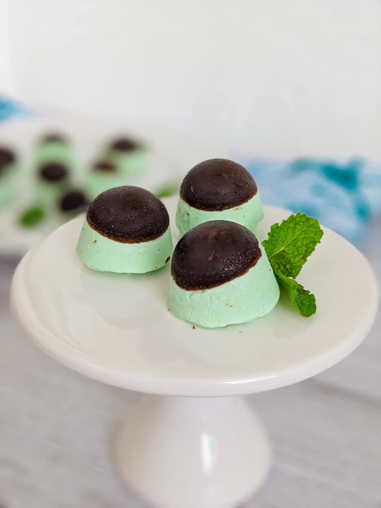 keto peppermint cream cheese fat bombs with mint leaves on small white pedestal