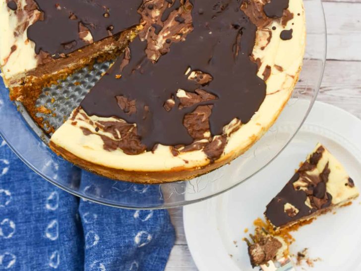 low carb marble cheesecake on cake stand and with a slice next to it.