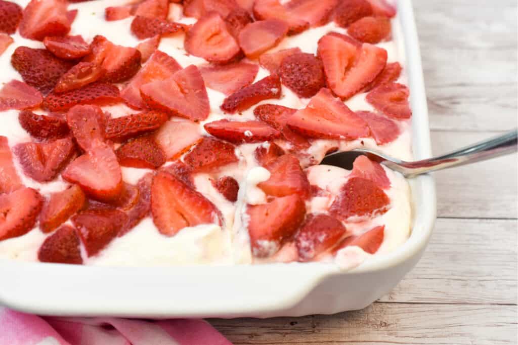 keto strawberry no bake cheesecake about to be served from a large white pan