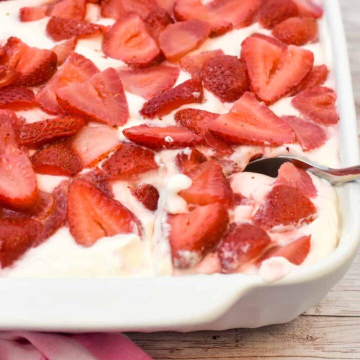 keto strawberry no bake cheesecake about to be served from a large white pan