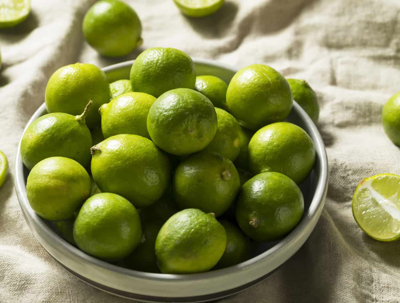key limes in a bowl on table cloth