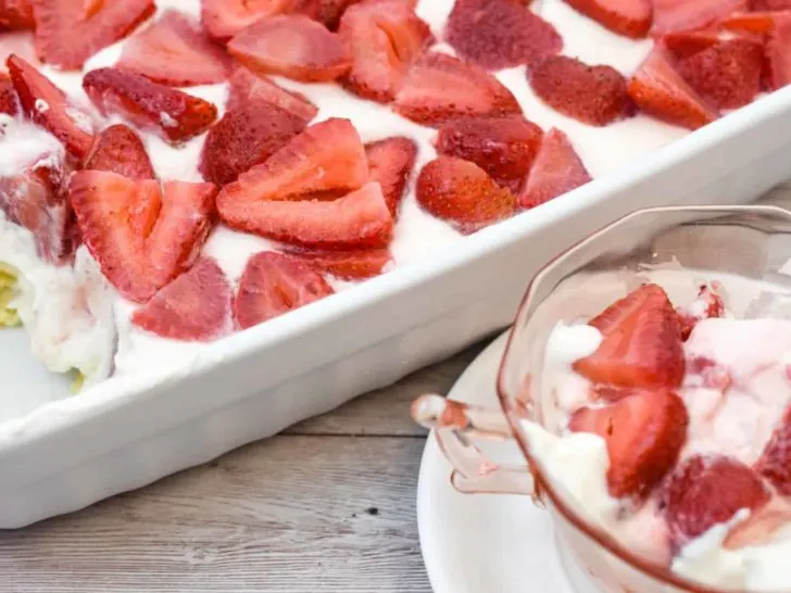 It's a picture of no bake keto cheesecake made in a rectangle pan topped with fresh strawberries