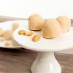 Cream Cheese Peanut Butter Fat Bombs on White Pedestal with Peanuts