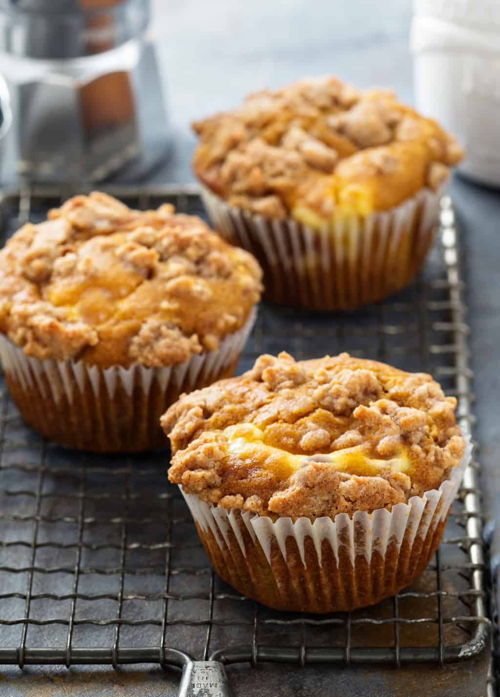 keto pumpkin cheesecake muffins on a baking rack cooling