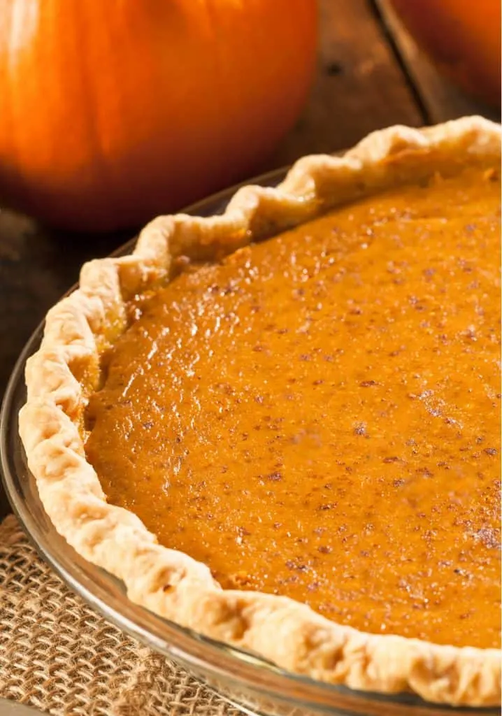 keto pumpkin pie with a pumpkins in the background