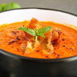 keto tomato bacon soup served in a small black and white bowl