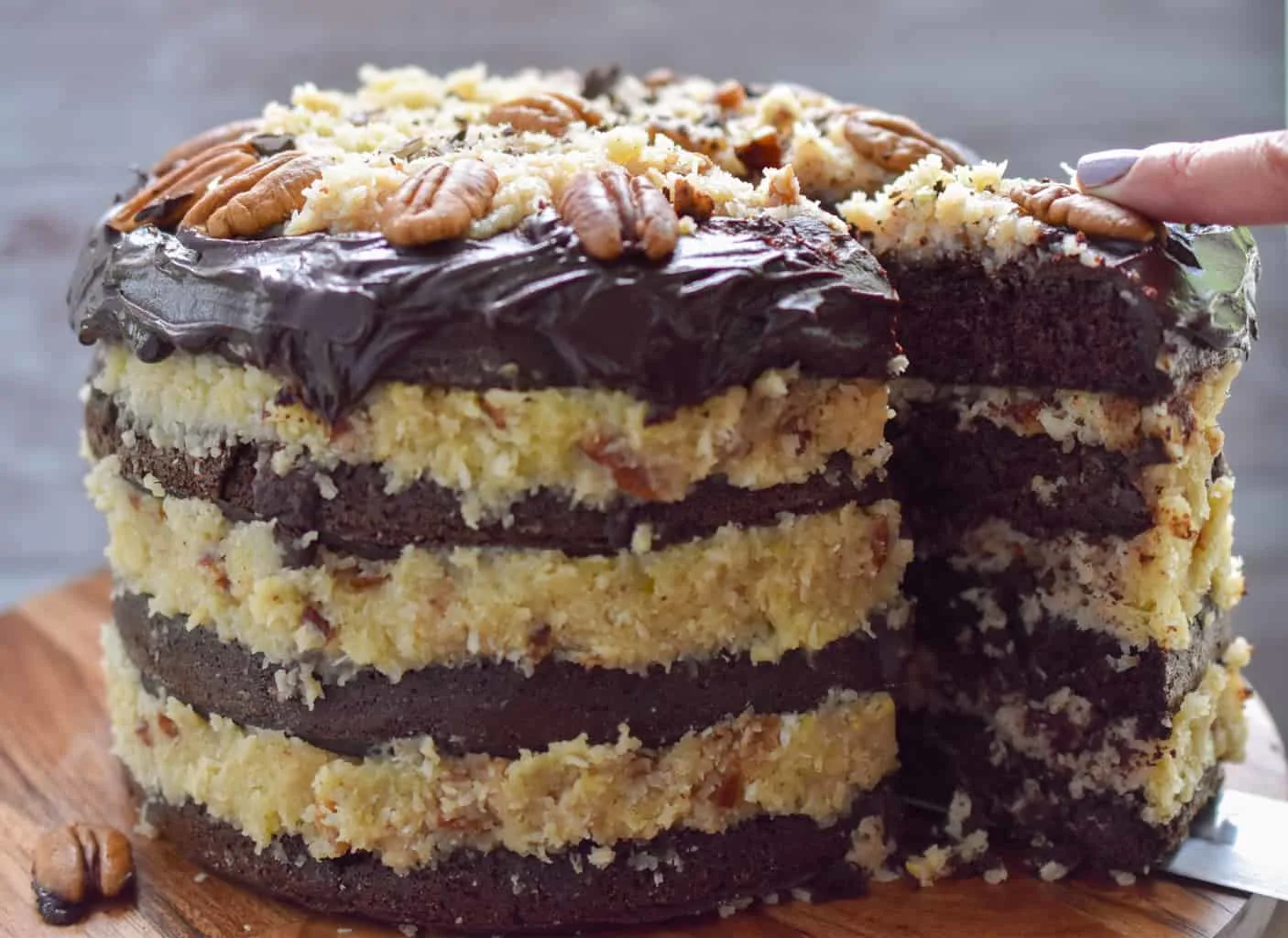 Four layer keto German chocolate layer cake being sliced