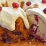 keto cranberry cake being sliced on wood cake stand