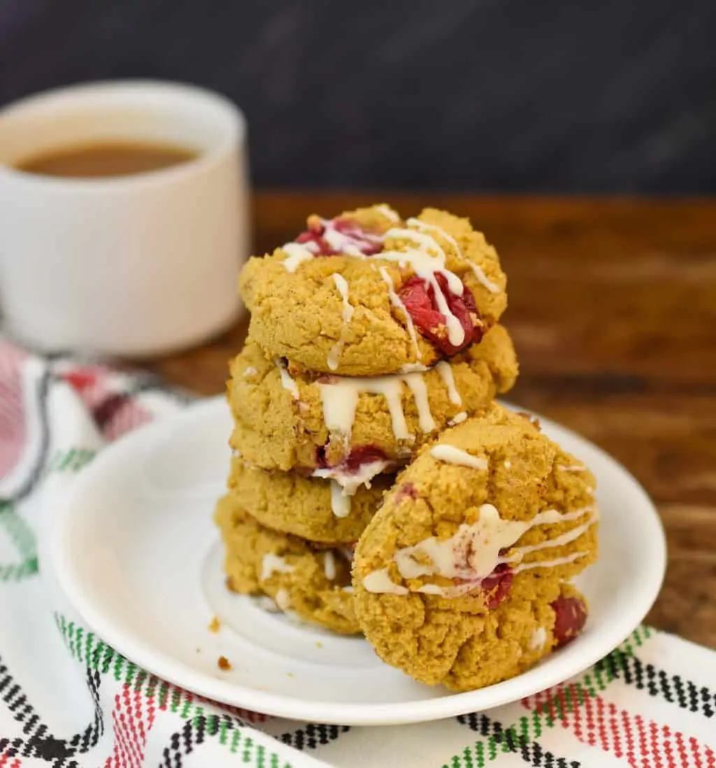 keto pumpkin cranberry cookies stacked on a white plate