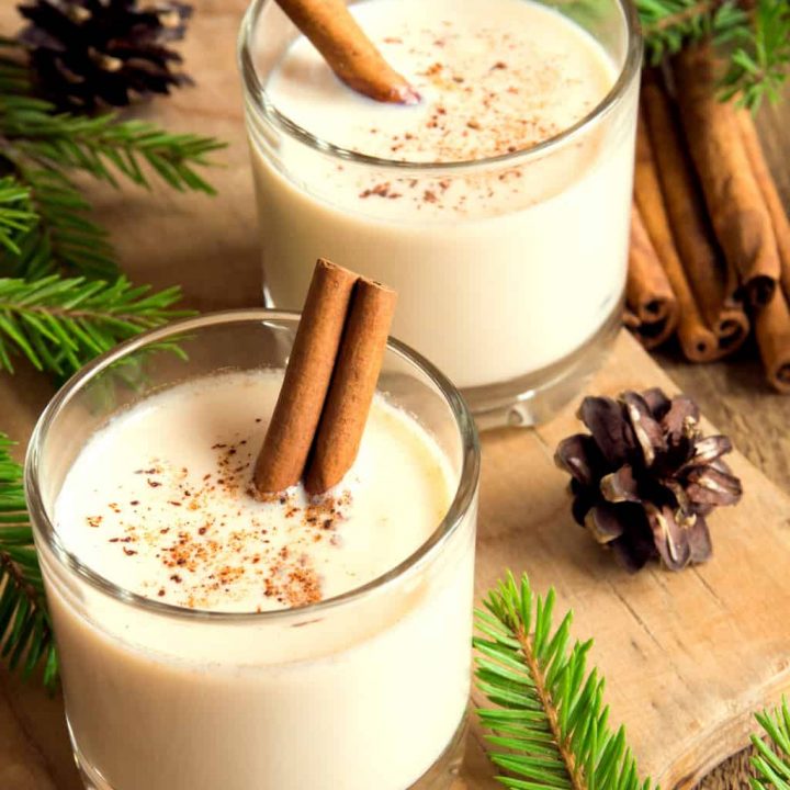 keto eggnog served in two clear glasses with cinnamon sticks