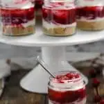 keto no-bake cranberry cheesecake minis on a white cake stand