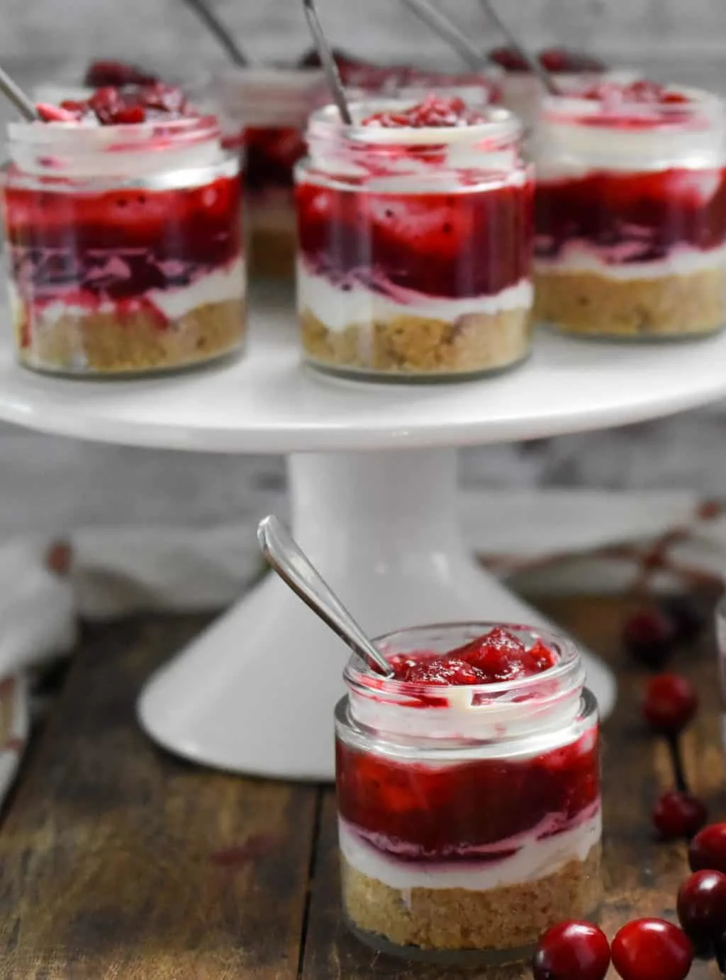 keto no-bake cranberry cheesecake minis on a white cake stand