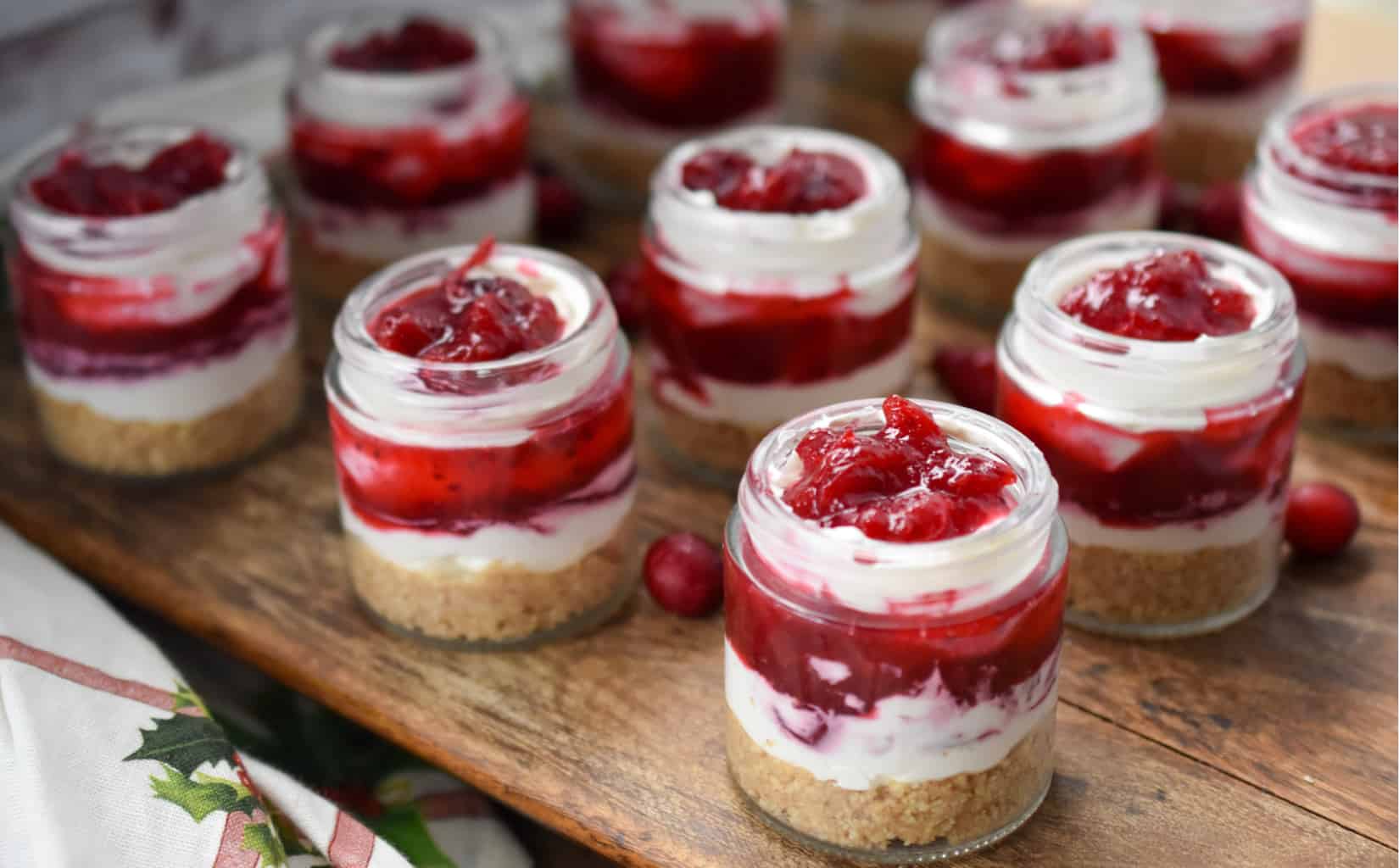 keto no-bake cranberry cheesecake parfaits on a wood board ready to serve