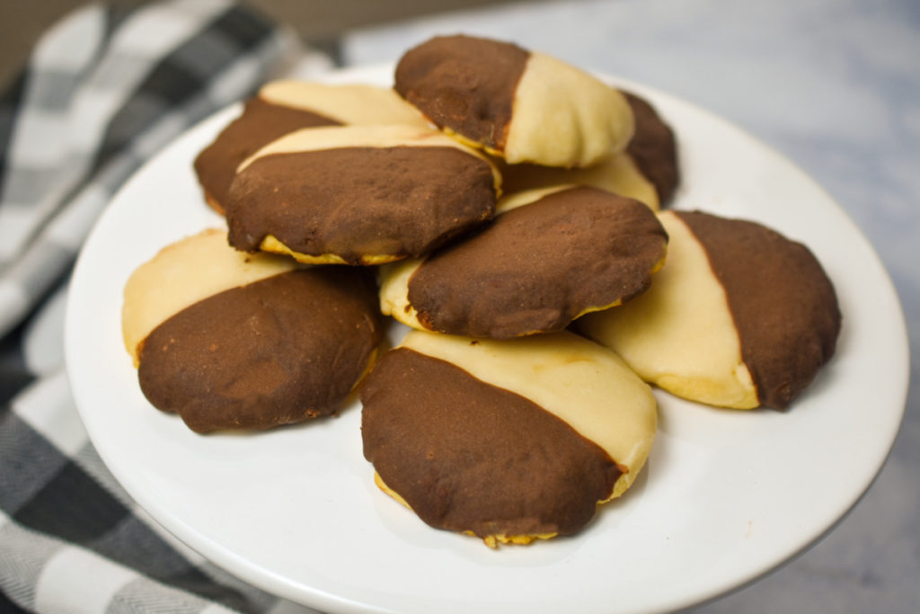 Keto black and white cookies served on a white pedestal stand