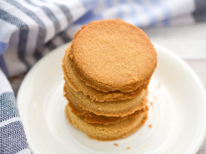 Keto coconut flour shortbread cookies stacked on a white plate