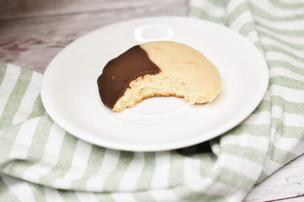 keto black and white cookies on white plate bitten