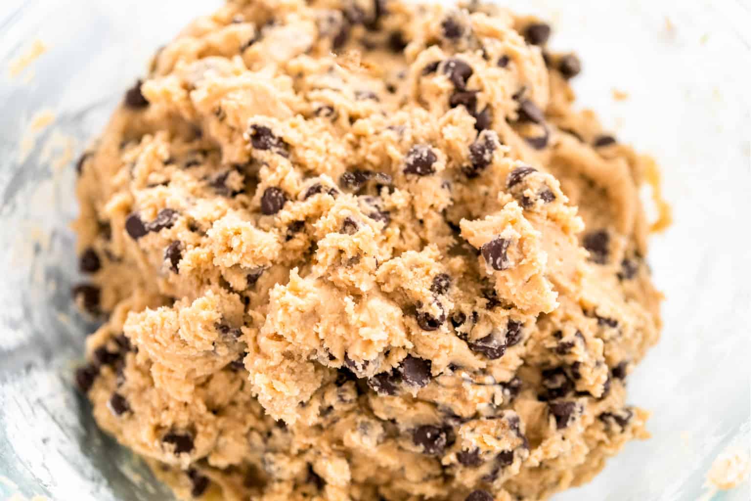 Mixing ingredients in a glass mixing bowl to bake keto brown butter chocolate chip cookies.