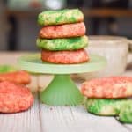 keto soft sugar cookies stacked on green stand and all over table