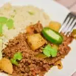 keto Mexican picadillo served cauliflower rice on plate with fork on the side close up