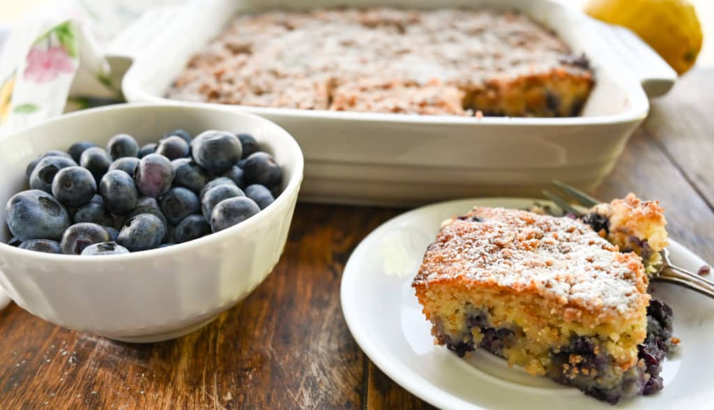 keto blueberry buckle cake with a side of blueberries in a small bowl