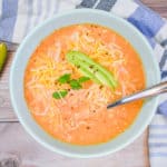 keto chicken taco soup in blue bowl with avocado on the side