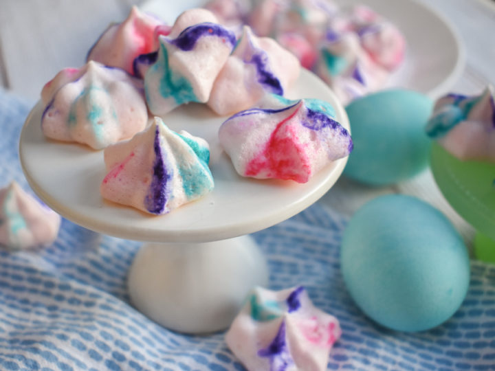 Low Carb French Meringues with easter eggs dyed blue next to them