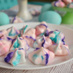 keto french meringues on white plate with blue dyed eggs in background
